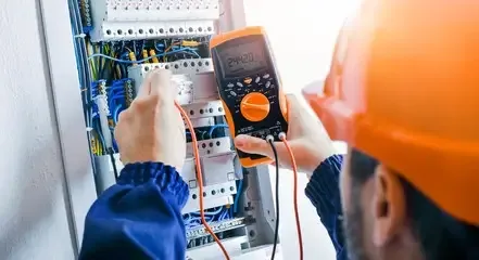 فني كهربائي بالرياض من عمر كهربائي وسباك يجري فحص لوحة كهربائية باستخدام جهاز قياس احترافي ضمن خدمات سباكة وكهرباء الرياض بأعلى معايير الجودة والسلامة.
